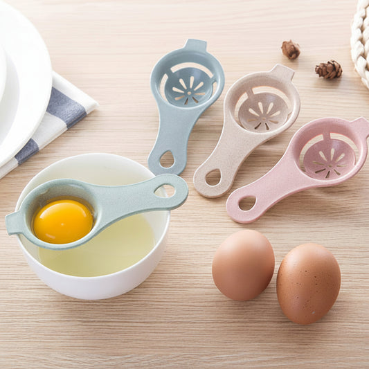 Three egg separators in blue, white, and pink on a wooden surface with eggs and a bowl.